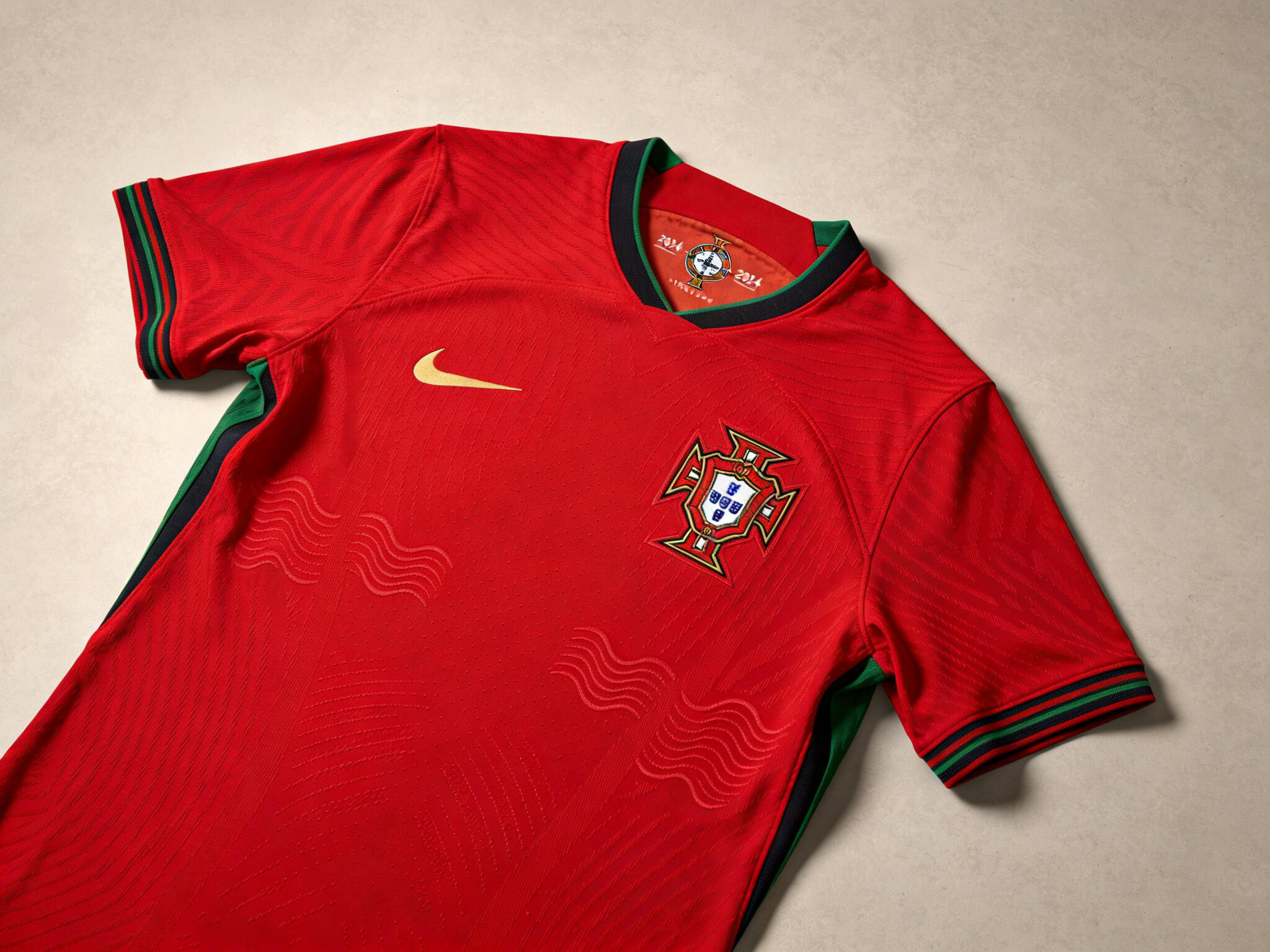 A high-quality, flat-lay close-up of the new Portugal 2024 home football jersey. Shows crisp details of the crest, fabric texture, and sleek side panel design.