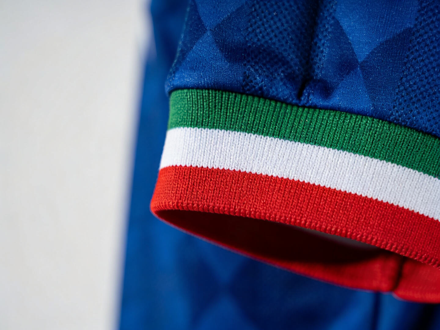 Close-up detail shot of the iconic tricolor sleeve against the blue body.